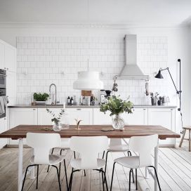 Celá bílá skandinávská kuchyně s dřevěným stolem