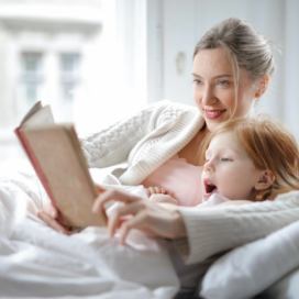 Máma a dcera v posteli s knihou
