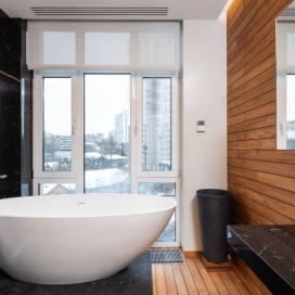 Koupelna s krásnou vanou a dřevěným obkladem