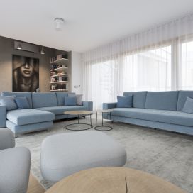Obývací pokoj s modrou sedačkou a velkým oknem Ambience Design.cz
